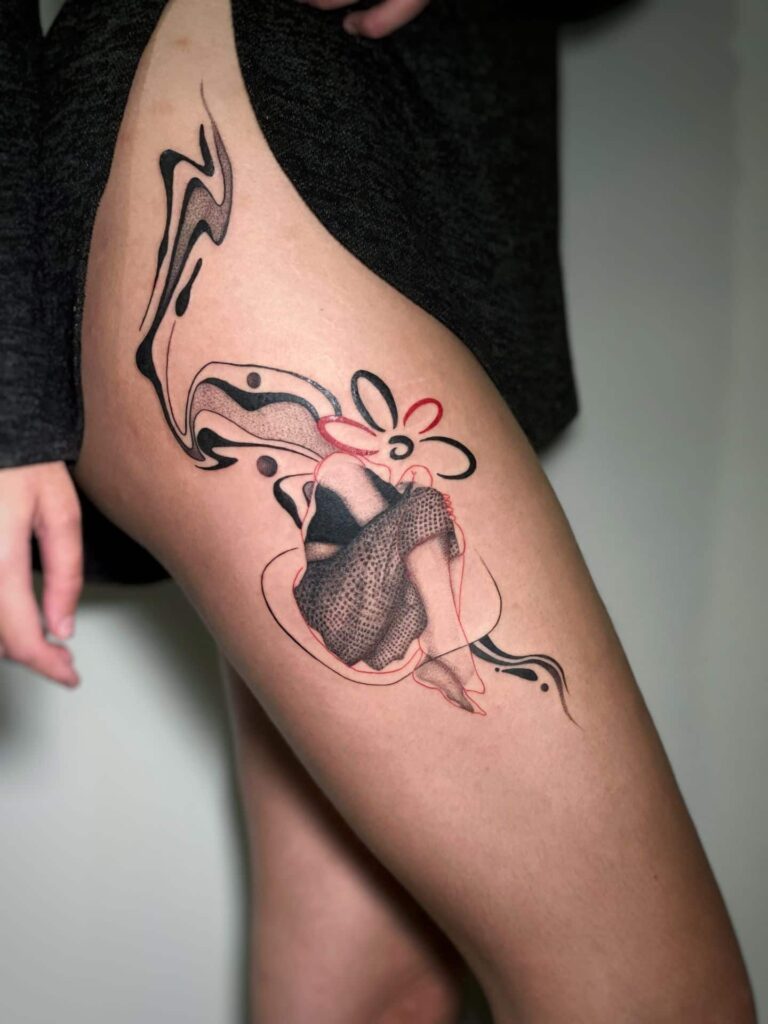 A close-up of a woman's thigh showcasing a tattoo of a woman intertwined with a beautiful flower design.