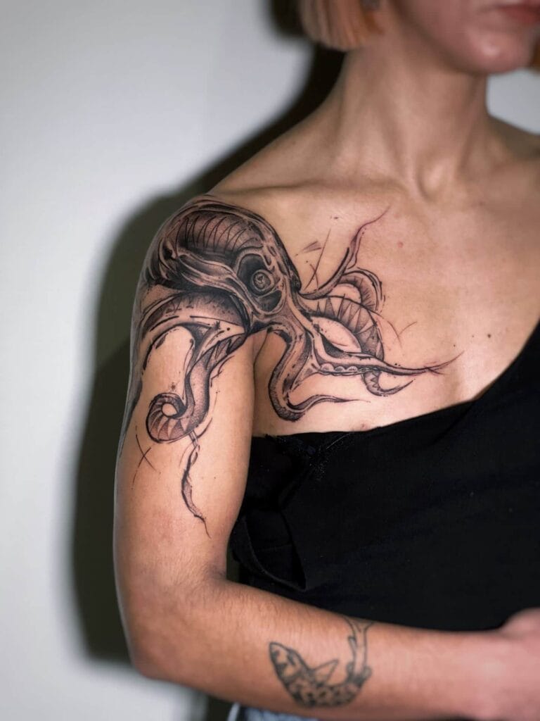 A woman shows off her shoulder tattoo of a vibrant octopus, showcasing intricate details and colors.