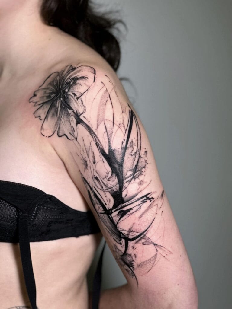 A woman showing off her arm tattoo featuring a beautiful flower design.