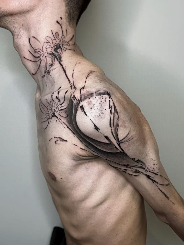 A man showing off a flower tattoo on his shoulder, highlighting his unique style and body art.