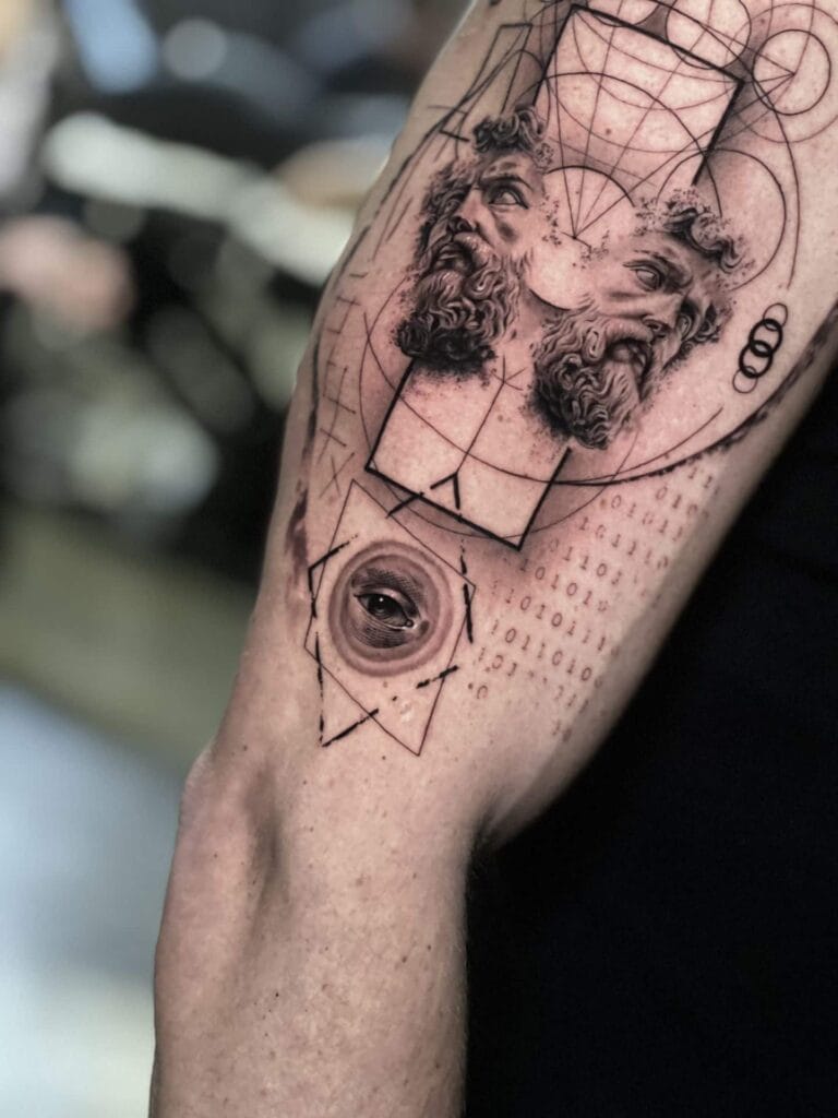 A man's arm showcasing a detailed geometric tattoo design, highlighting sharp lines and intricate patterns.