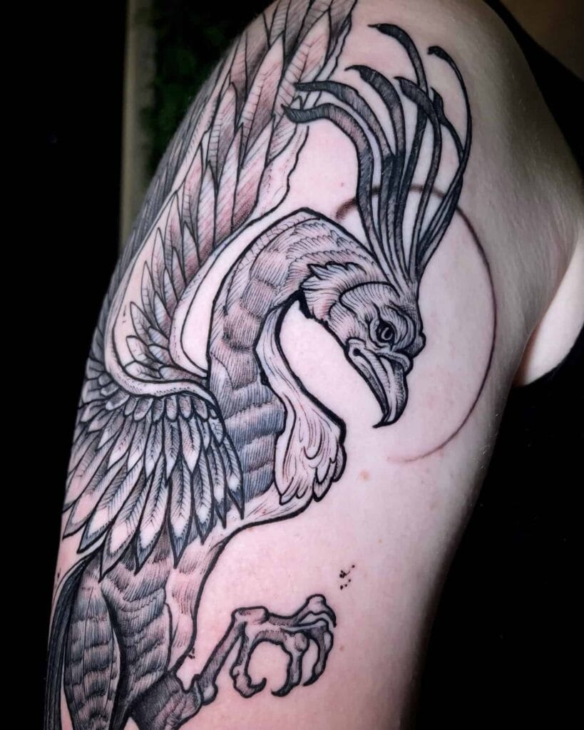 A detailed tattoo of a bird with outstretched wings inked on a person's arm.