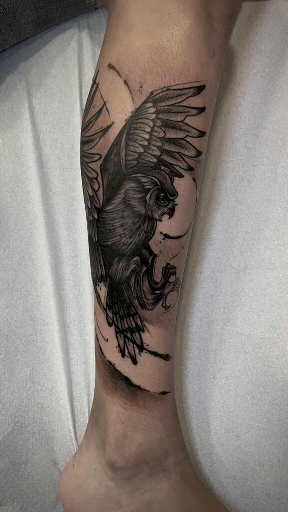 Tattoo of a detailed owl inked on a person's leg, showcasing intricate feathers and captivating eyes.