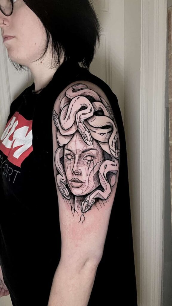 A woman proudly displays her arm tattoo featuring a striking snake design.