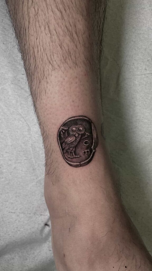Tattoo of a coin inked on a man's ankle, showcasing intricate details and a unique design.