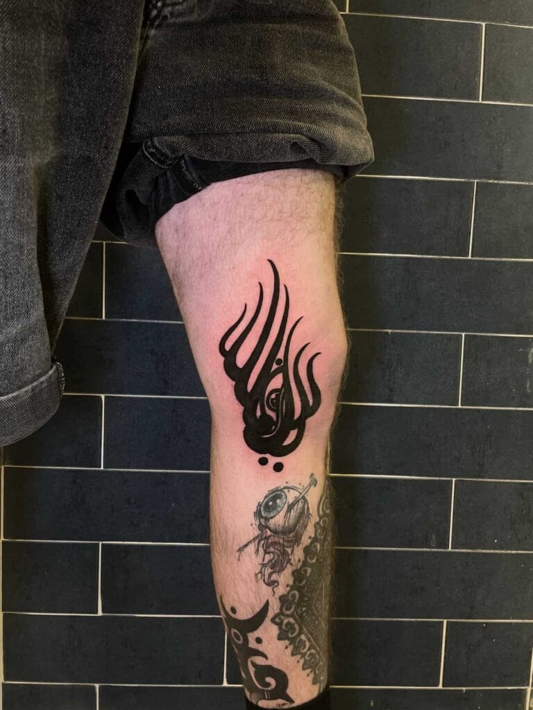 A detailed tattoo of a dragon inked on the leg of a man, showcasing intricate scales and fierce expression.