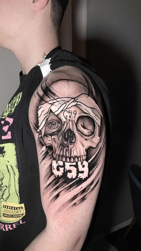 A man displaying a skull tattoo on his arm, showcasing intricate details and bold lines in the design.