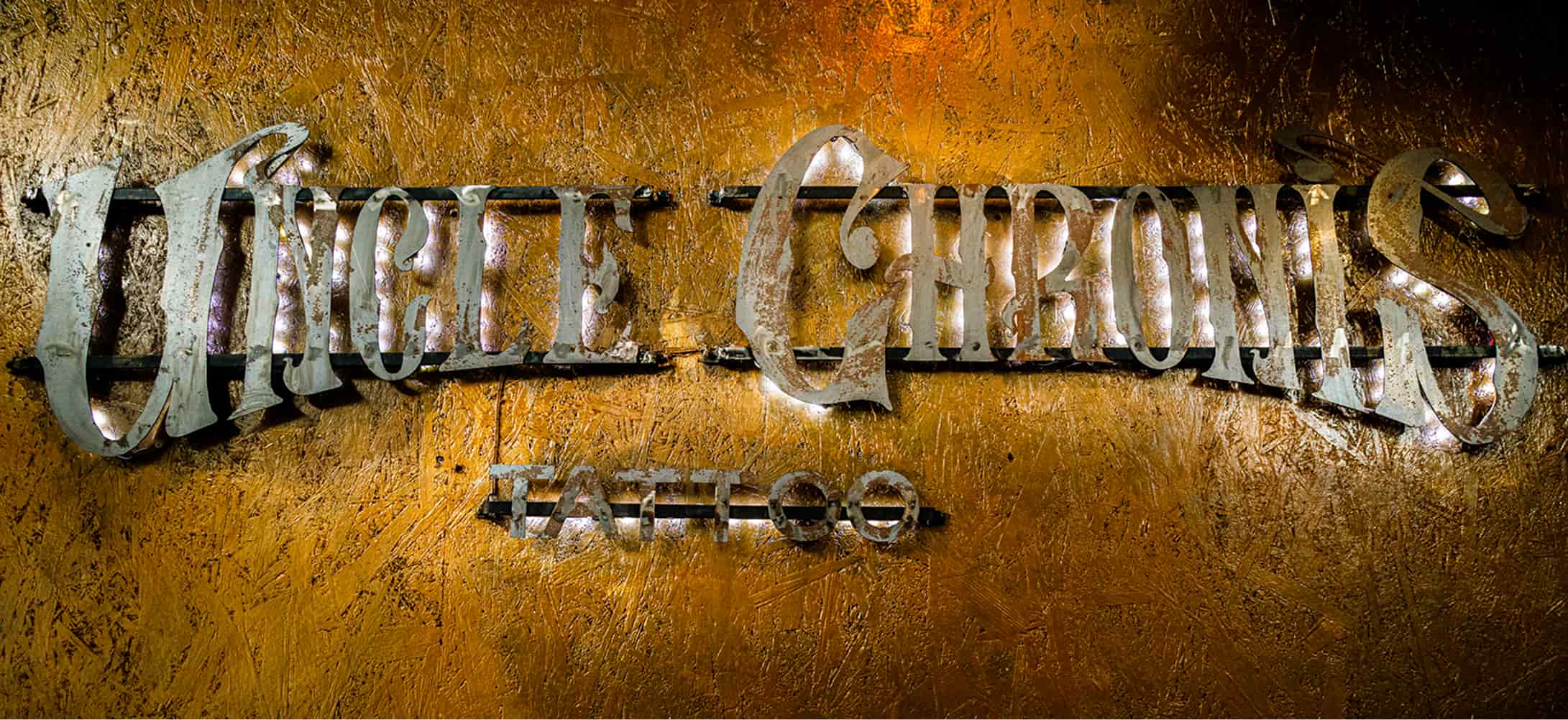 The Unclechronis Tattoo Studio sign displayed prominently, featuring eye-catching graphics and bold lettering.